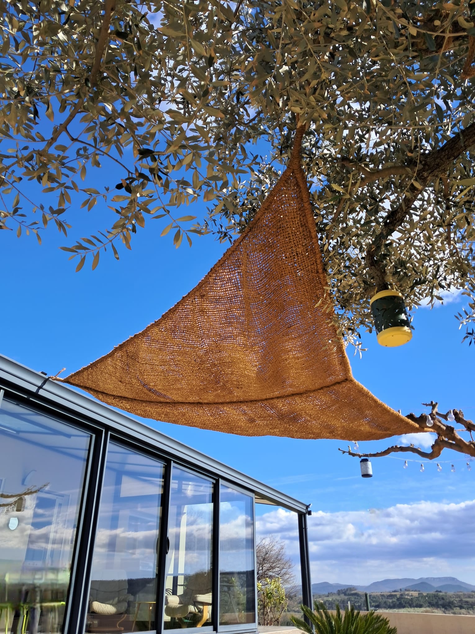 Voile d'ombrage triangulaire en fibre de coco 3,5x3,5x3,5m installé en extérieur - Tiens-toi à l'ombre
