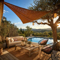 Voile d'ombrage triangulaire Alizé en fibre de coco naturelle tendue sur une terrasse bohème chic avec piscine et vue sur les collines du sud de la France
